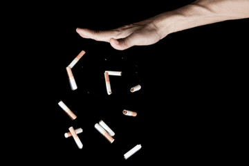 Obraz premium Hand throwing cigarette tobacco with motion freeze on black background , no smoke stop quitting sign tobacco day