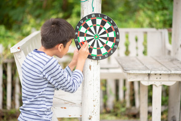 Little boy playing darts board family outdoor activity