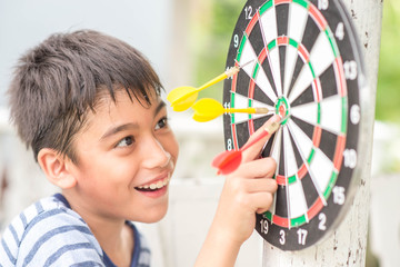 Little boy playing darts board family outdoor activity