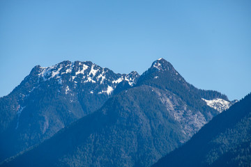 Fototapeta na wymiar snow covered mountain range under clear blue sky on a sunny day on early spring