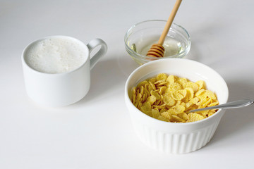Healthy breakfast with cornflakes and milk over white background