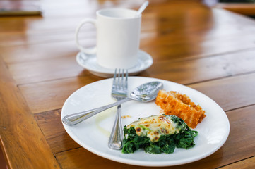 Baked Spinach with Cheese with deep fried chicken on white ceramic plate