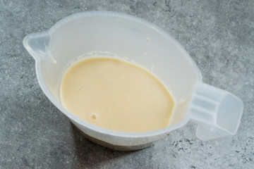 Raw Pancake Dough in Plastic Carafe Ready to Pour on Pan.