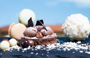 Chocolate tart slice with macaroons, chocolate chips. Selective focus