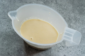 Raw Pancake Dough in Plastic Carafe Ready to Pour on Pan.