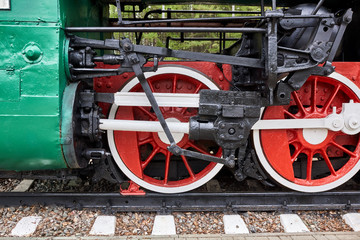 Steel wheels old steam locomotive standing on rails, vintage train, close-up