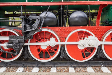 Steel wheels old steam locomotive standing on rails, vintage train, close-up