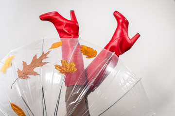 Female legs wearing red  high heels boots with umbrella