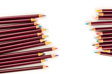 Many different colored pencils forming a frame, shot from the top on a white background with a place for text