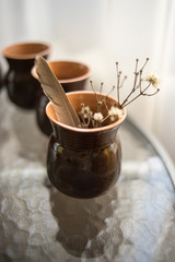Dry flowers and feather in ceramic vase