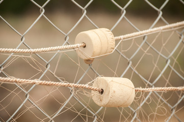 Fishing net with cork floats on wire mesh closeup as decorative background