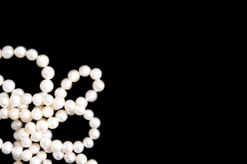 White pearls necklace on black background