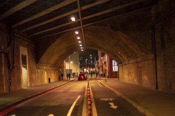 London tunnel with yellow lights and dark road