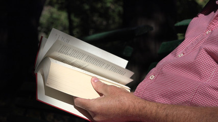 Man In Park Sit on a Bench Relaxed and Read a Literature Book 