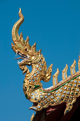 Fototapeta na wymiar Chiang Rai Thailand, dragon finial decorating rooftop of wat jed yod