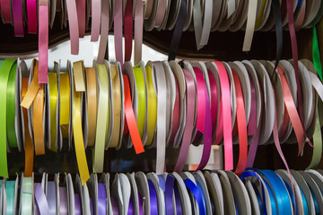 multicolored threads and ribbons. Background for the store selling reels with ribbons. materials for sewing and creativity. Fashionable craft of women. Shop for creativity.