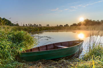 Naklejka na ściany i meble Wooden boat on the river bank. Morning Countryside. Dunilovo, Ivanovo Region Russia