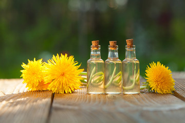 dandelion essential oil in  beautiful bottle on table © solstizia
