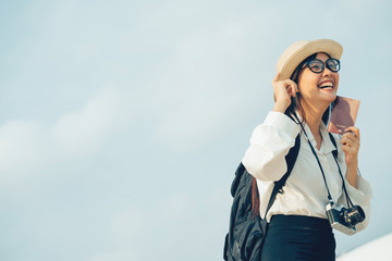 Happy woman with camera and passport waiting for travel by plane. Travel concept with copy space
