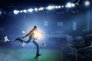 Fototapeta na wymiar Virtual Reality headset on a black male playing soccer. Mixed media