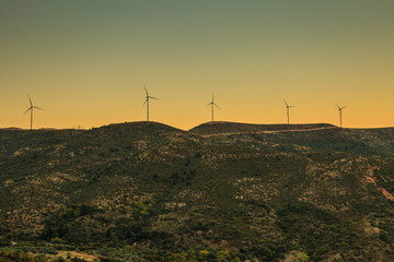 wind turbines farm at sunset in mountains