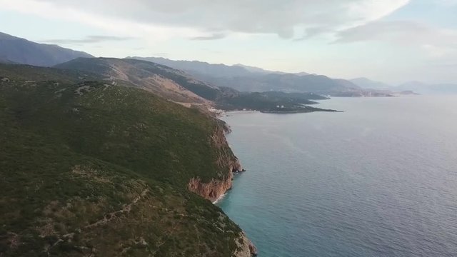 Stunning views from Gjipe Beach and Gjipe Canyon along the Albania Riviera during sunset. Views over the mountain range that meet the Adriatic Coastline with caves and beaches to explore on vacation