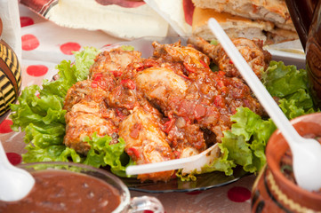 Chicken stew with vegetables and spices - chakhokhbili close-up on the table.
