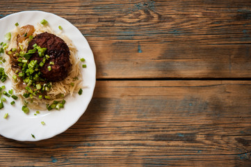 cutlets with pasta on a plate on a wooden background