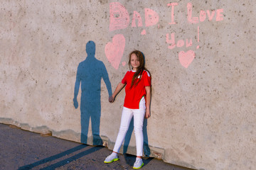 Obraz na płótnie Canvas Happy dad holds daughter's hand. Shadow of dad and daughter on the wall. On the wall the inscription Dad I love you. Concept of happy father day.