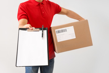 Delivery man with box and clipboard on white background