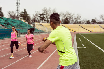Obraz premium Man holding stop watch while women running 