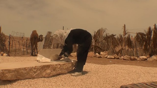 Bedouin woman prepares traditional bread
