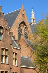 Fototapeta na wymiar The external facade of Grote of Sint Jacobskerk with the turret of Oude Stadhuis (Old Town Hall, 16 century) in the background, The Hague, Netherlands
