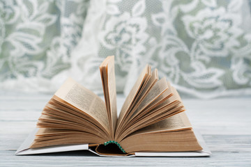Open hardback book, on wooden table. natural background . Back to school. Copy space for text.