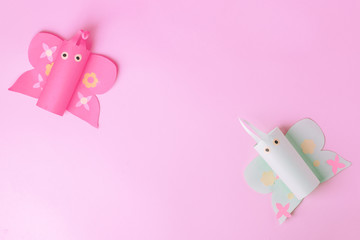 Minimal easter holiday spring summer time pink concept - couple of papaercraft handmade naive butterfly on pink candy color background, cute creative idea