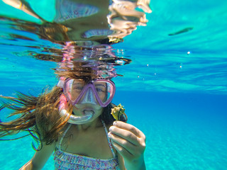 Sweet girl under the sea with a seashell