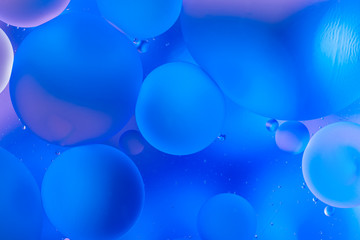 oily drops in water with colorful background, close-up 