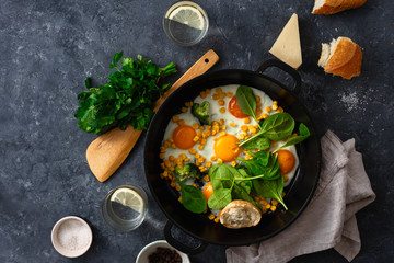 Breakfast fried eggs frying pan top view on dark stone background