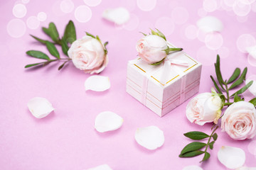Rosebuds, petals,, gift box on a pink background. Concept for a greeting card. Weddings, Valentine's Day, Birthday