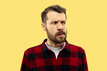 Obraz premium Half-length close up portrait of young man in shirt on yellow background. The human emotions, facial expression concept. Front view. Trendy colors. Negative space. Serious and thoughtful looking.