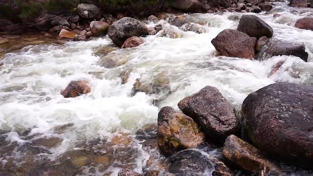Slow-motion video of rapids with strong currents and whitewater in the river dee in the cairngorms in the schottish Highlands, Scotland, United Kingdom.