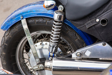 Obraz premium Parts of a racing motorcycle. Wheel, shock absorber and exhaust pipe close-up.