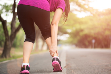 Woman suffering from an ankle injury while exercising. Running sport injury concept.