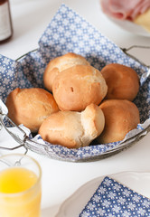 Traditional German Kaiser rolls or Austrian Vienna rolls homemade from yeast dough with white wheat flour in vintage bread basket with blue and white paper napkin on weekend breakfast table