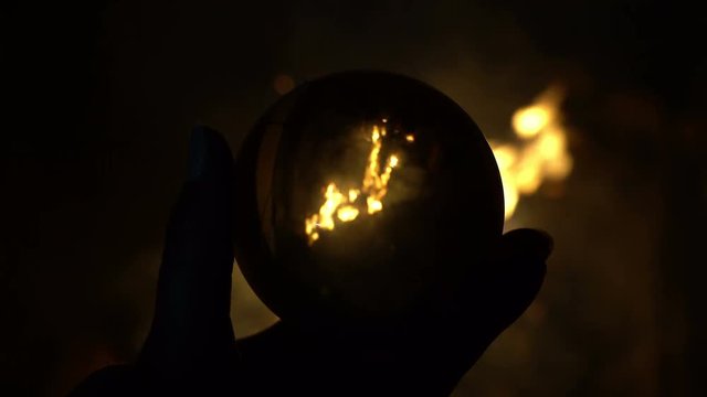 Camp fire reflection in crystall ball, magic energy, witch making prediction, shamanism occultism