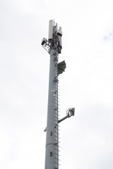 Communication steel tower against cloudy sky background