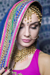 Portrait of a female model in ethnic indian costume with  jewellery and traditional makeup.