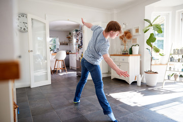 Young Downs Syndrome Man Having Fun Dancing At Home