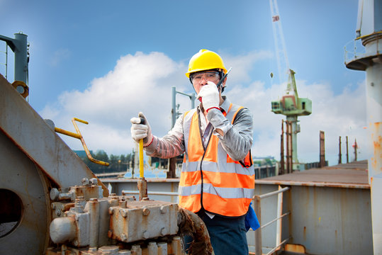engineering or worker, motor man, loading master controller working in communication by walkie talkie to the team for safety loading winch of the crane, lifting gears operation in industrial work site