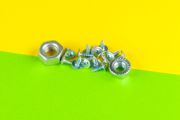 Top view of stainless steel bolts or iron nails on bright green background